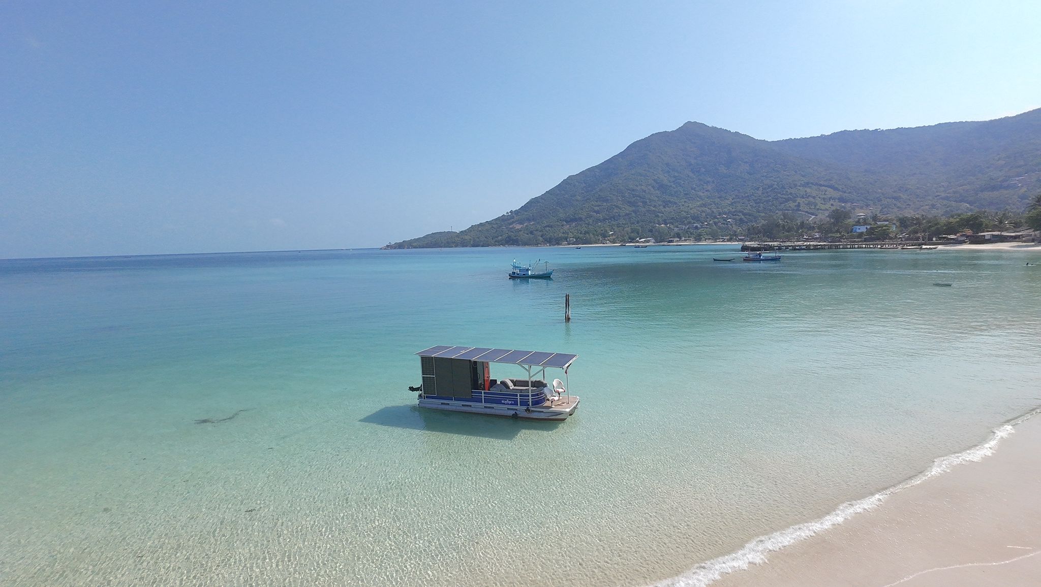 Side view of SolarStorm electric boat in turquoise water